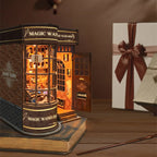 Magic Wand Store book nook resting on a book beside a ribboned gift box and a wand prop