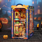 Plaza de los Muertos book nook glowing at night beside jack-o-lanterns and a castle backdrop